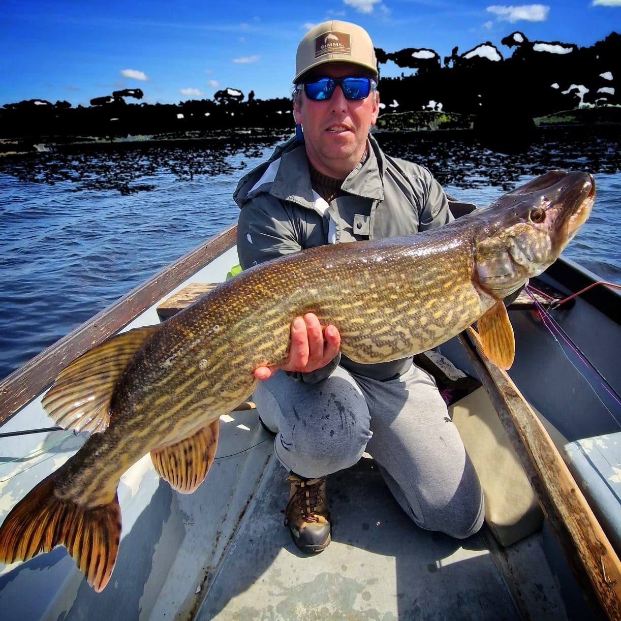A large pike held boatside on Lough Erne