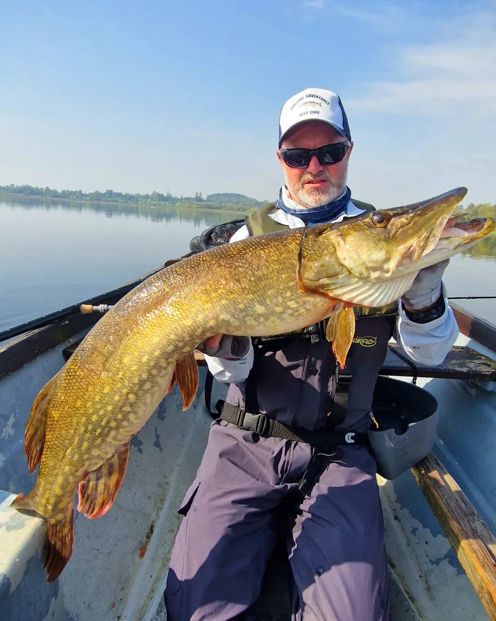 A heavy Lough Erne pike held over the boat