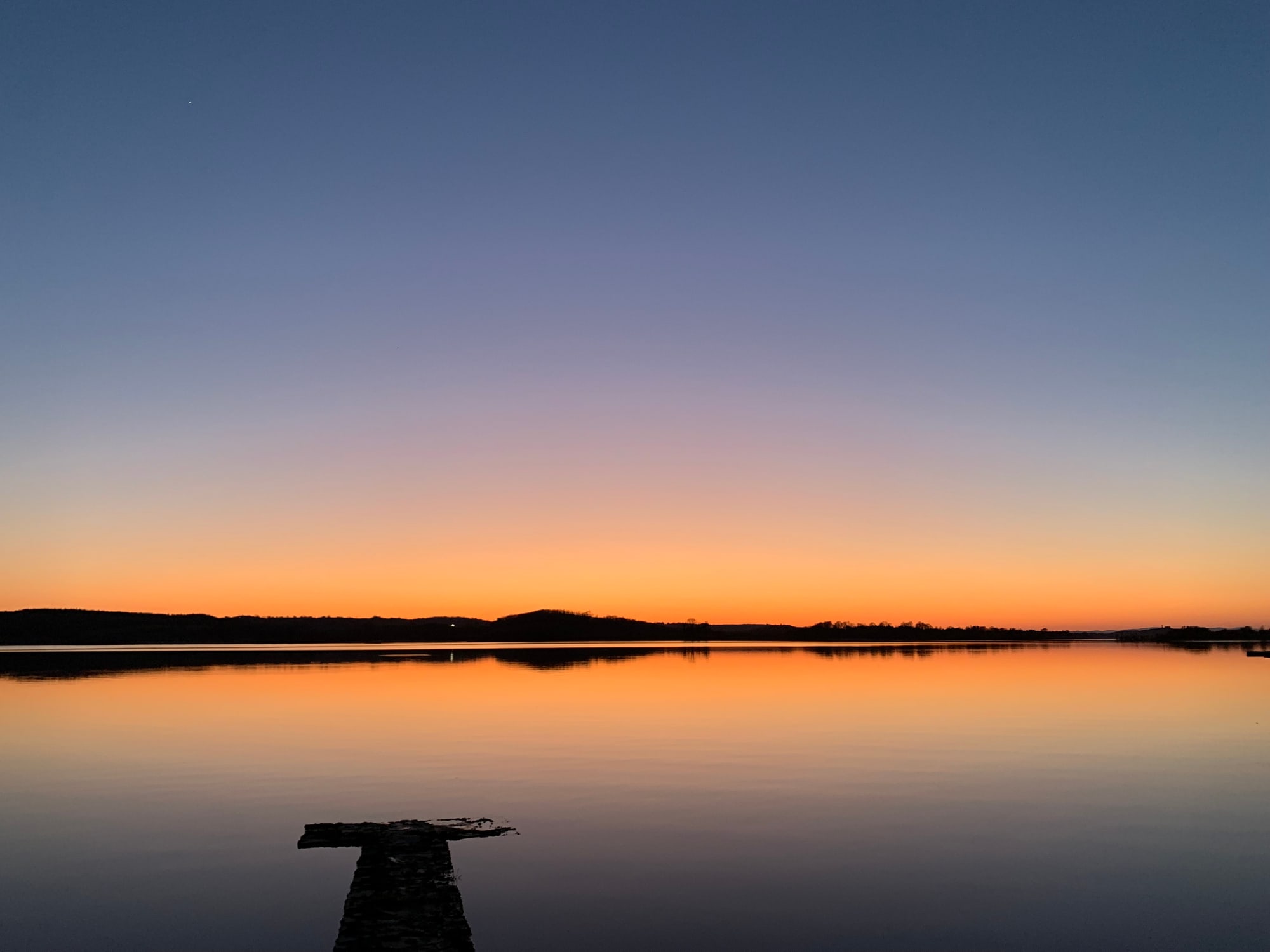 Sunset over Lower Lough Erne from Trory jetty, the water completely still